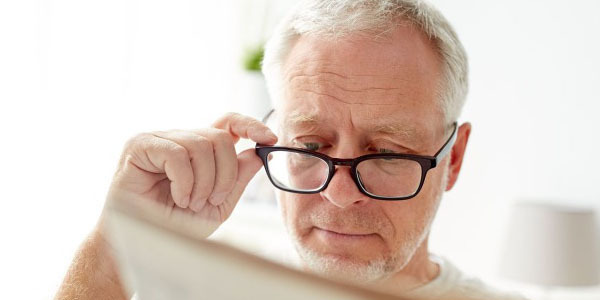 Older man wearing glasses and reading