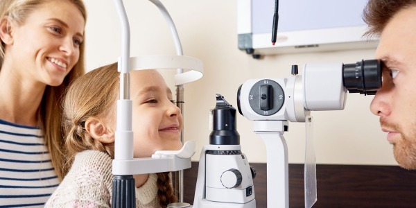 Smiling girl with optical equipment