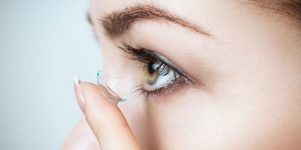 Lady inserting a contact lens into her eye